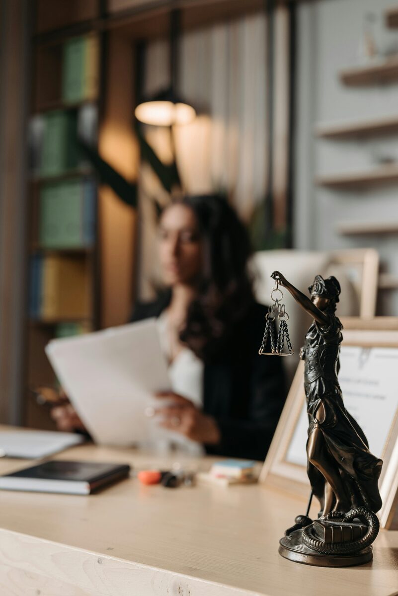 A bronze statue of Lady Justice holding scales, in a quiet office